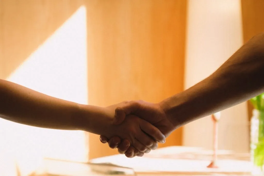 Handshaking in bright office